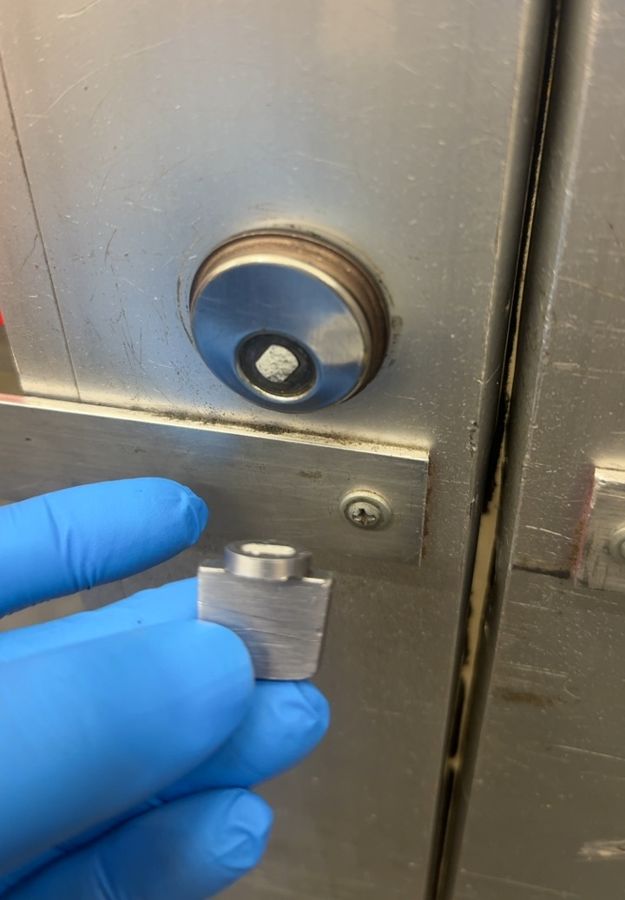 Storefront door cylinder with the plug missing, new cylinder in hand, Gastonia NC